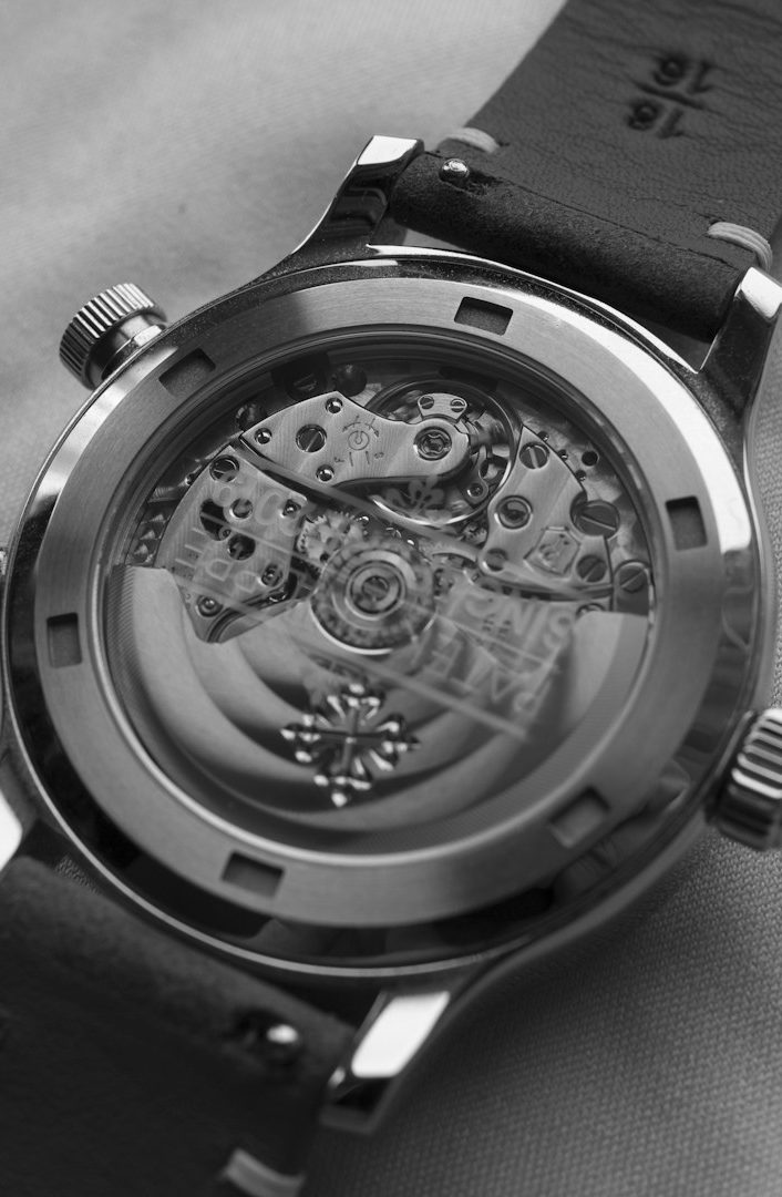 Uhr mit transparentem Gehäuse, sichtbare Uhrwerke und Lederarmband.