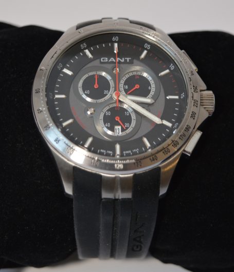 Schwarze Armbanduhr mit silbernem Gehäuse, Chronographen und schwarzem Gummiarmband.